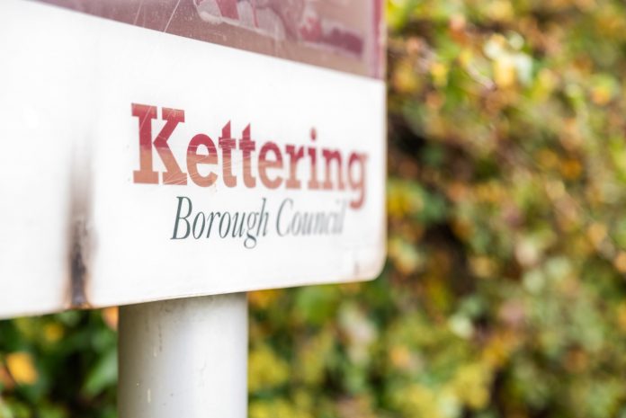 Kettering borough council text on board stand in England UK New homes, homes england,