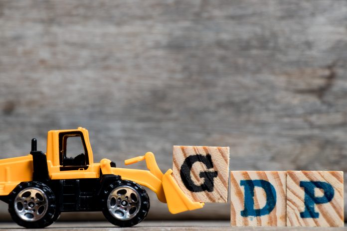 Yellow plastic bulldozer hold letter G to complete word GDP (Abb monlthy GDP estimates