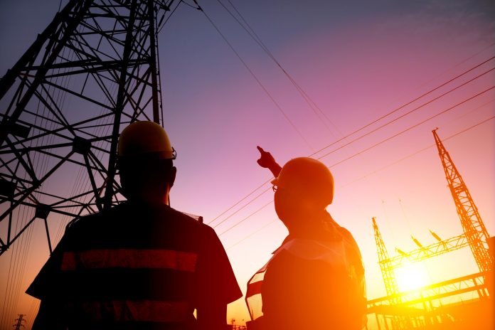 two worker watching the power tower and substation with sunset b littlebrook power station, high-voltage substation,