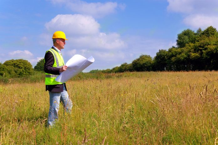 Architect surveying a new building plot measurement of land, RICS,