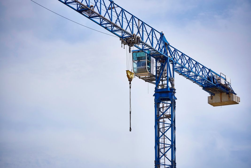 A high-altitude crane close-up against a cloudy blue sky. Off-Site Solutions Awards,