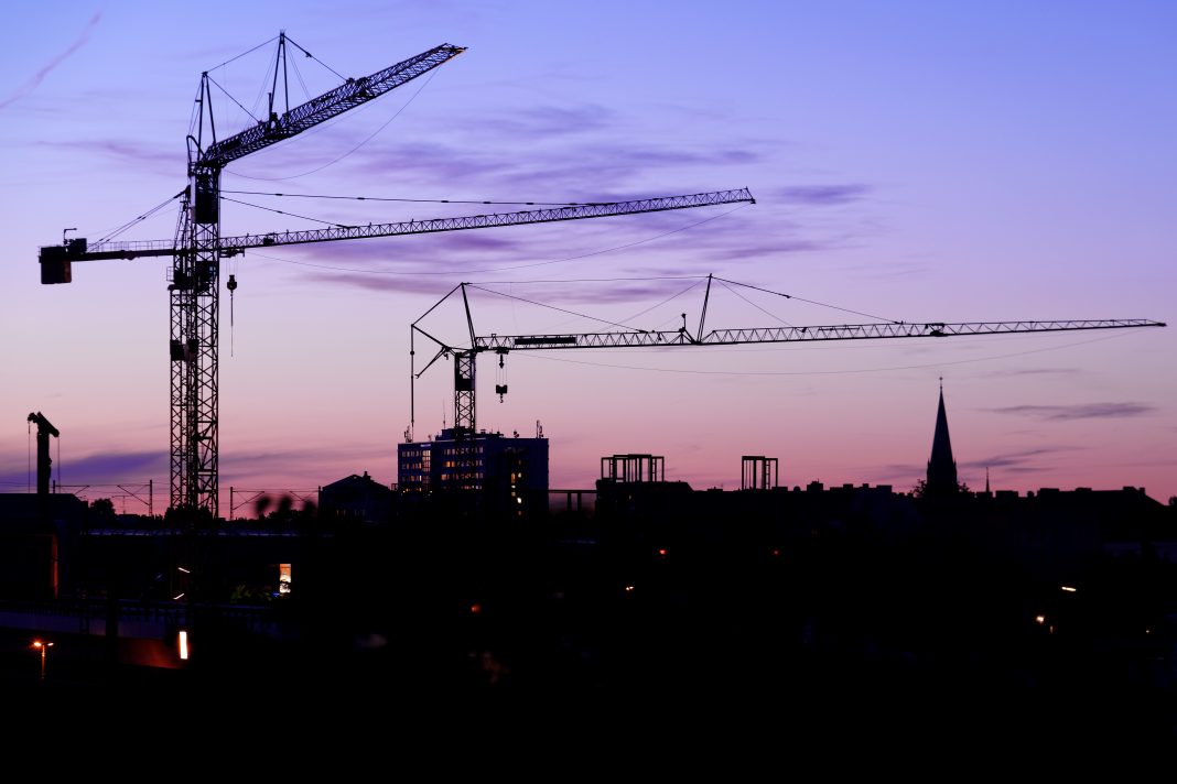 Crane on a construction site at night in Berlin future of the construction industry,
