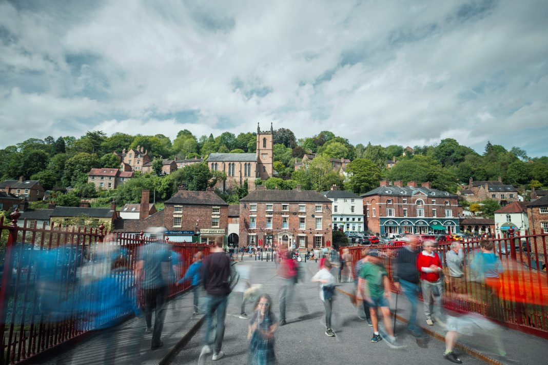 Crowd of Tourist Crossing Historic Bridge in Ironbridge town centre development, risk management,