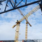 Construction site with steel frame structure and crane.