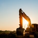 Track-type loader excavator machine on sunset background