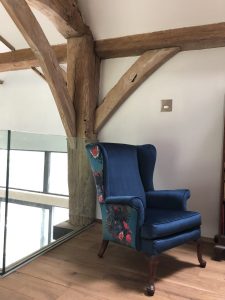 arm chair upstairs under woodern beams in converted barn