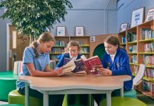 Children sat at table reading in new Burton-on-the-Wolds Primary School library
