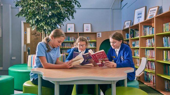 Children sat at table reading in new Burton-on-the-Wolds Primary School library