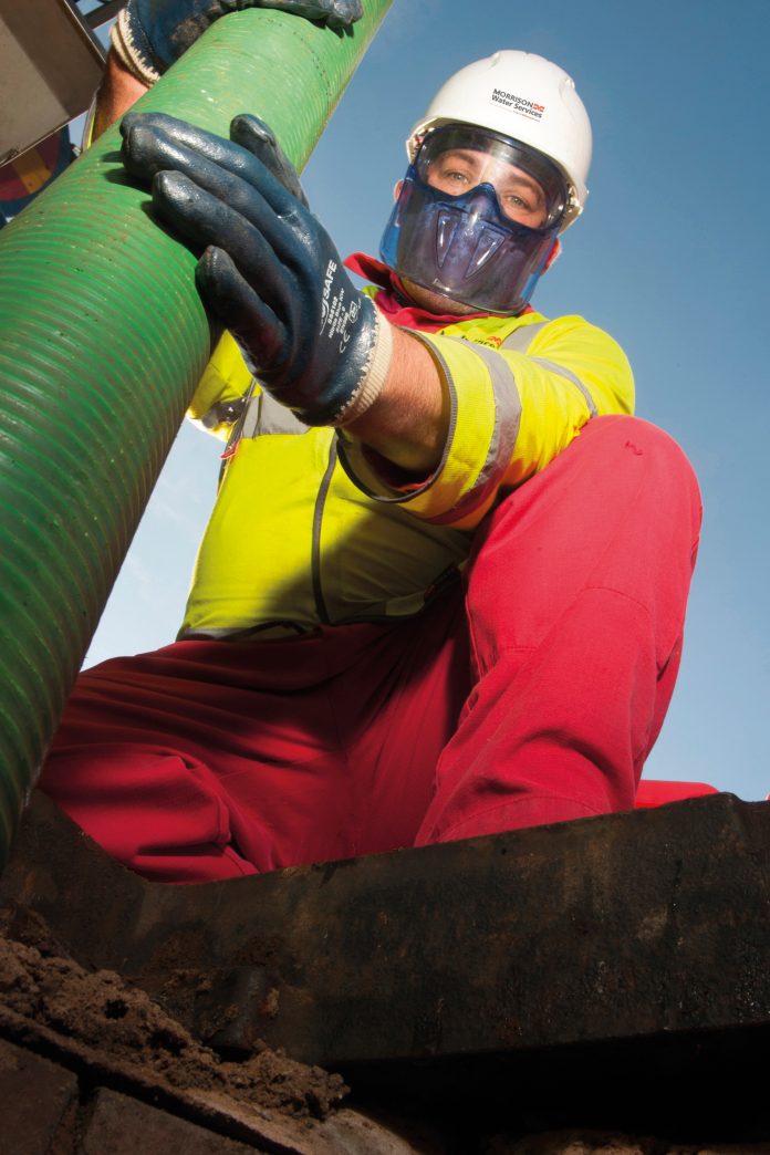 Image of worker holding wastewater pipe