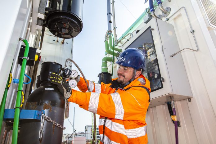 A worker checks the valves of the GeoPura hydrogen power units used in HS2's hydrogen generator trial