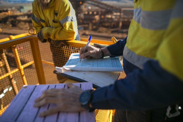 Worker signing construction records on site