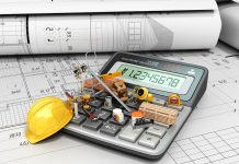 miniature construction equipment on top of calculator used for self build construction blue print plans