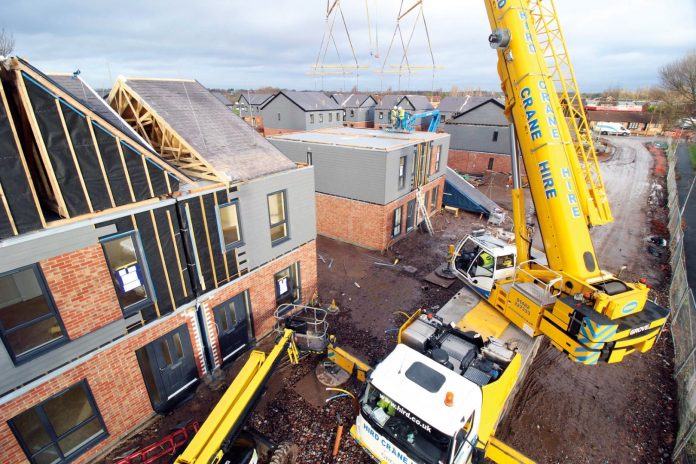 Modular contractors working on construction site to deliver offsite homes