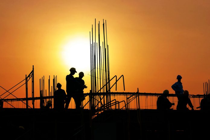 Workers on construction site in sunset