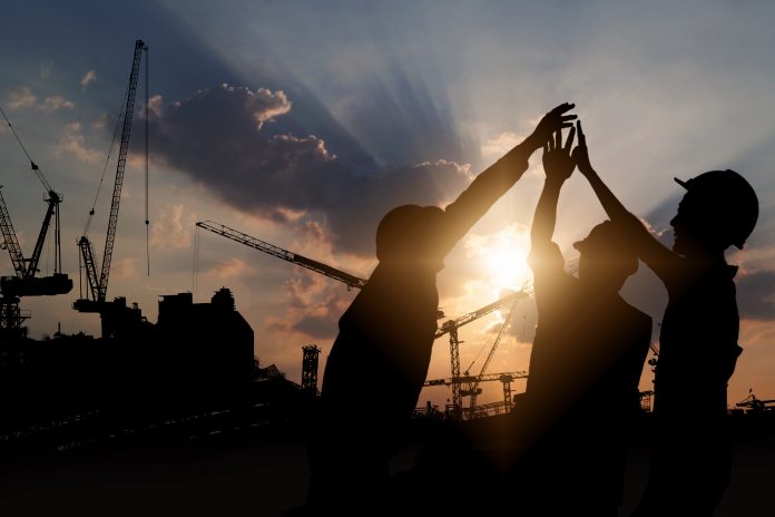 stock image of construction workers celebrating on site