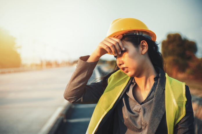 Engineer women wipe sweat and hot weather at site construction