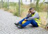 depressed construction worker sat against wire fence