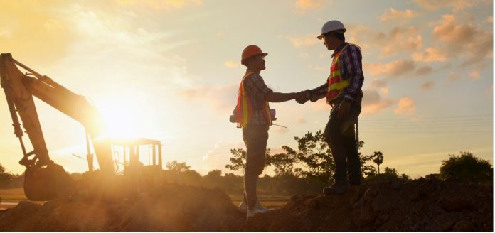 construction workers shaking hands at construction site over nec contracts