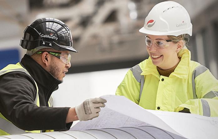 Galliford try employees discussing construction plans - Galliford Try becomes first construction company to give cost of living payment to employees