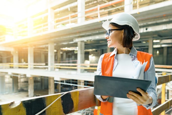 young construction worker surveying site
