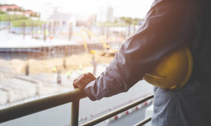 dreamstime_xxl_118666122 construction worker overlooking site