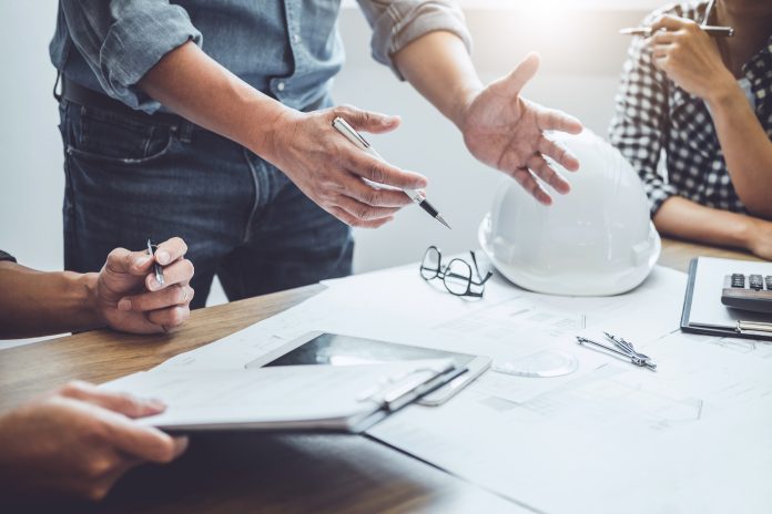 Construction and structure concept of Engineer or architect meeting for project working with partner and engineering tools on model building and blueprint in working site, existing construction contracts for both companies