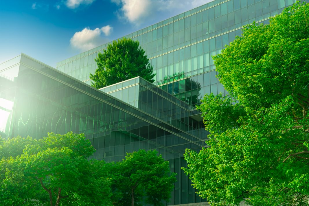 Office building with green environment, representing The annual RICS Sustainability Report has been released today (22 September), which highlights a rise in demand for sustainable commercial property in the UK, however the built environment must progress on decarbonisation