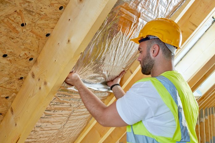 worker installing retrofit insulation
