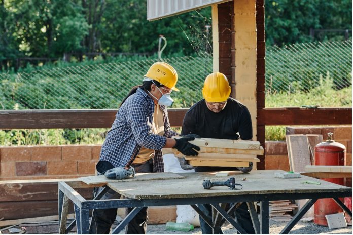 workers cutting wood on construction site
