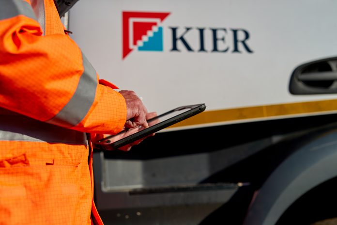 Operative in orange hi-vis holding an iPad, as Kier will offer apprenticeships for prisoners in its Highways division following a change in the law which means that prisoners can now earn while they learn