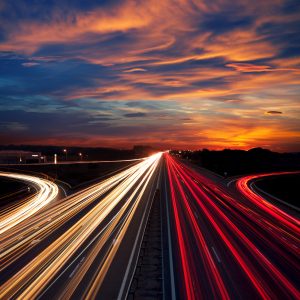 Speed Traffic at Dramatic Sundown Time - light trails on motorway highway at night, long exposure abstract urban background