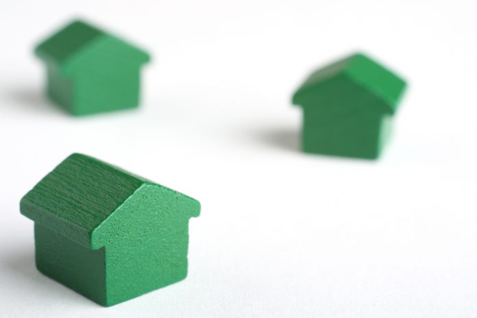 dreamstime_m_8130791 (1) mini green wooden houses (monopoly) on white back drop