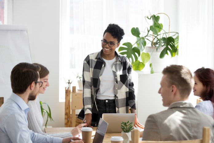 dreamstime_xxl_138763469 coach satisfied with office briefing having good relations and friendly conversation with workers