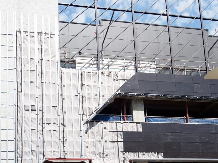 Safety cladding on exterior scaffolding on a mid rise building construction site