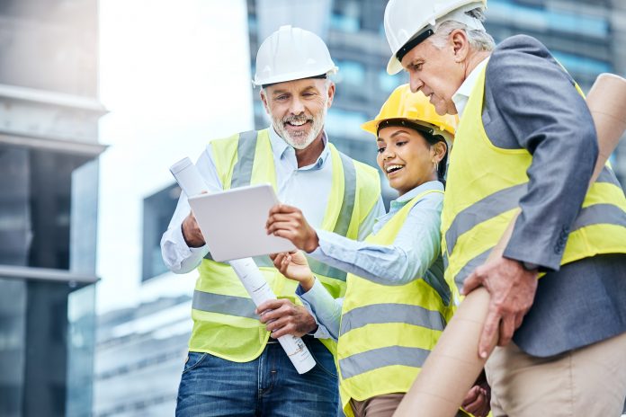businesspeople using a digital tablet while working at a construction site