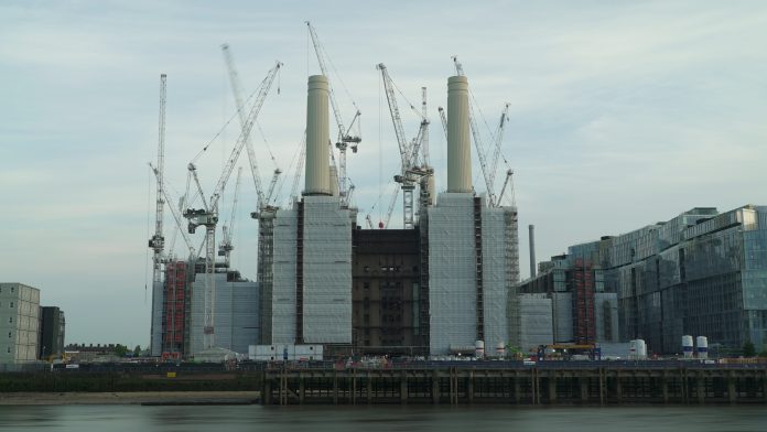 sky line of cranes surrounding high rise buildings - concept of regenerating old buildings