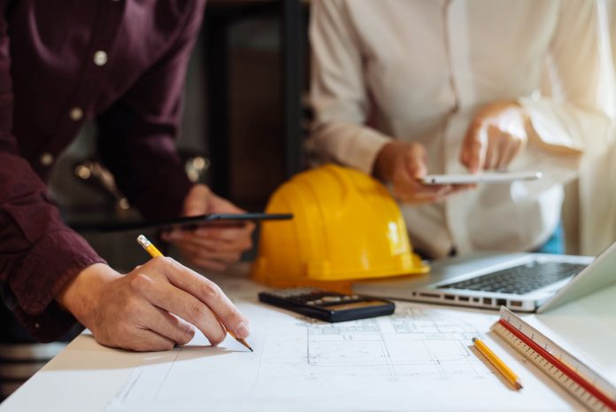 construction worker figuring out blueprints using data-driven insights on tablet