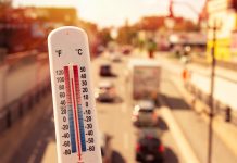 How tech can harden UK’s vital infrastructure against extreme weather thermometer with moving traffic in background - concept of the effects of extreme weather on the UK's vital infrastructure