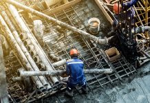 RICS UK construction and infrastructure monitor Q3 2022 Construction workers wear protective clothing and yellow helmets