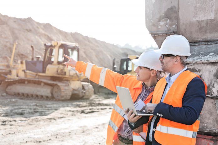 construction workers using laptop on site