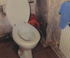 An image from the inquest into the death of Awaab Ishak, showing extensive black mould around the toilet in the family home