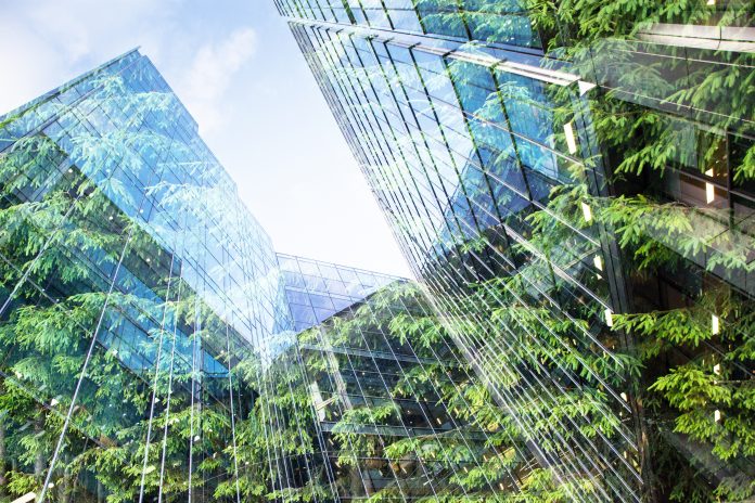 dreamstime_xxl_144567141 green city - double exposure of lush green forest and modern skyscrapers windows