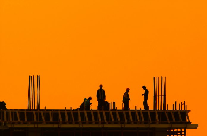 construction workers on top of building during sunset