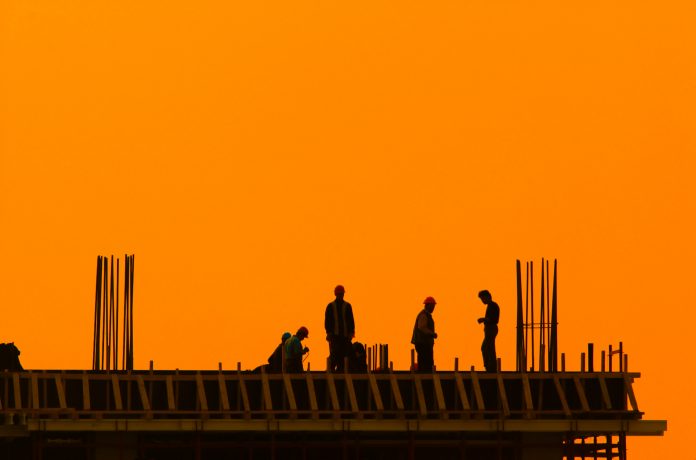 construction workers on top of building during sunset