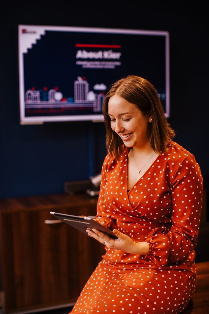 Female employee using tablet in meeting room at Kier office Female employee using Peppy digital health app in meeting room at Kier office