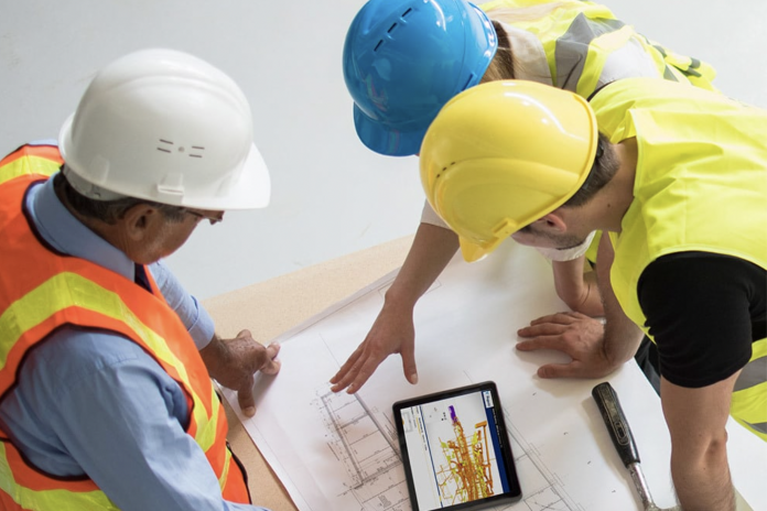 3 construction workers using Viewpoint For Projects on tablet