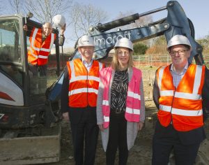 Former Transform CEO Paul Mitchell (on digger) with Transform Chair Mark Austen, Transform Head of Housing & Support Natalie Murphy, and Rollalong Sales Manager Nigel Allen.