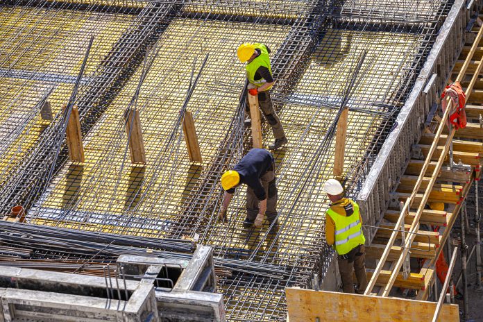 Workers make molds for reinforced concrete from reinforcing bars construction employment