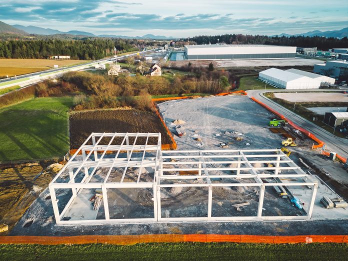 Warehouse Construction from metal structure. Industrial building on light gauge steel framing. Frame of modern hangar or factory. Construction site with steel structure warehouse. Top view on a roof. High quality photo
