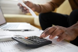 man with calculator checking bills 